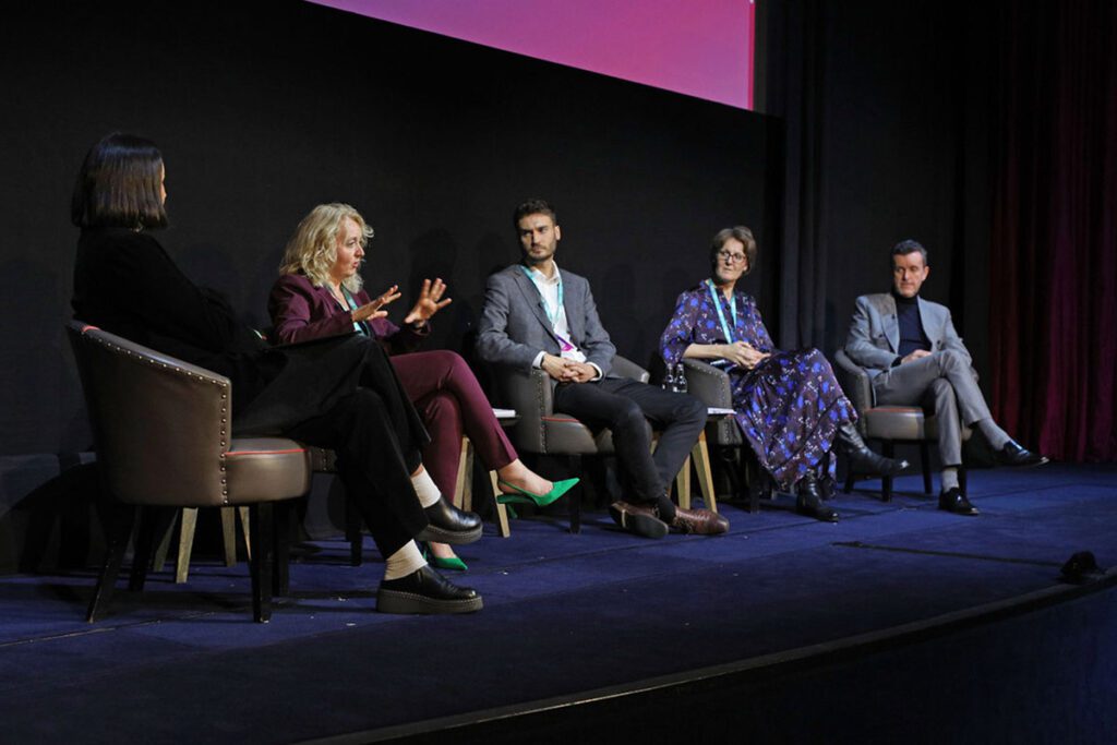 Four leaders onstage speaking in a panel at an event
